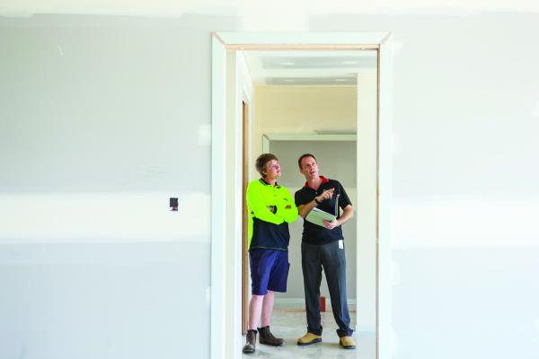 contractors discussing construction of an internal door frame